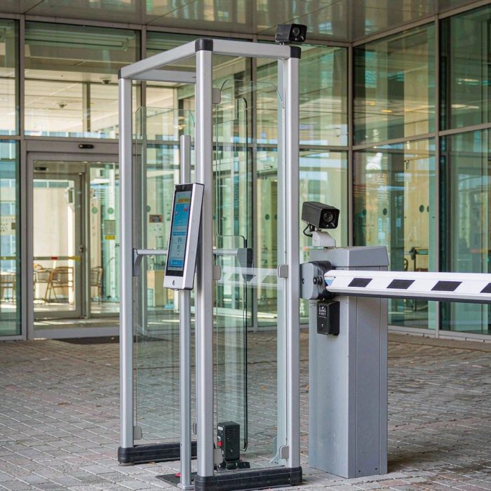 Pedestrian face recognition turnstile gate beside an automatic vehicle barrier gate with ANPR camera